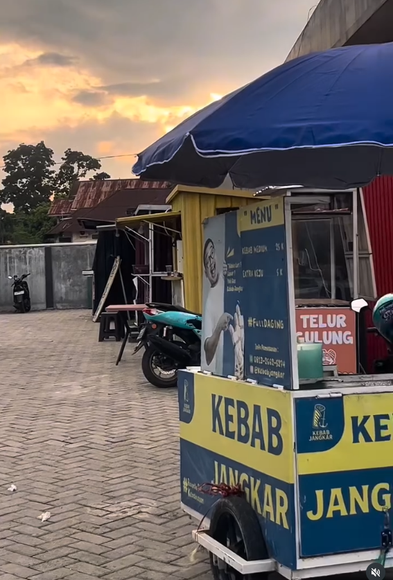 Suasana warung lokal dengan pemilik sedang menggunakan tablet POS modern